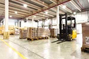 Organized pallets and forklift in a warehouse.